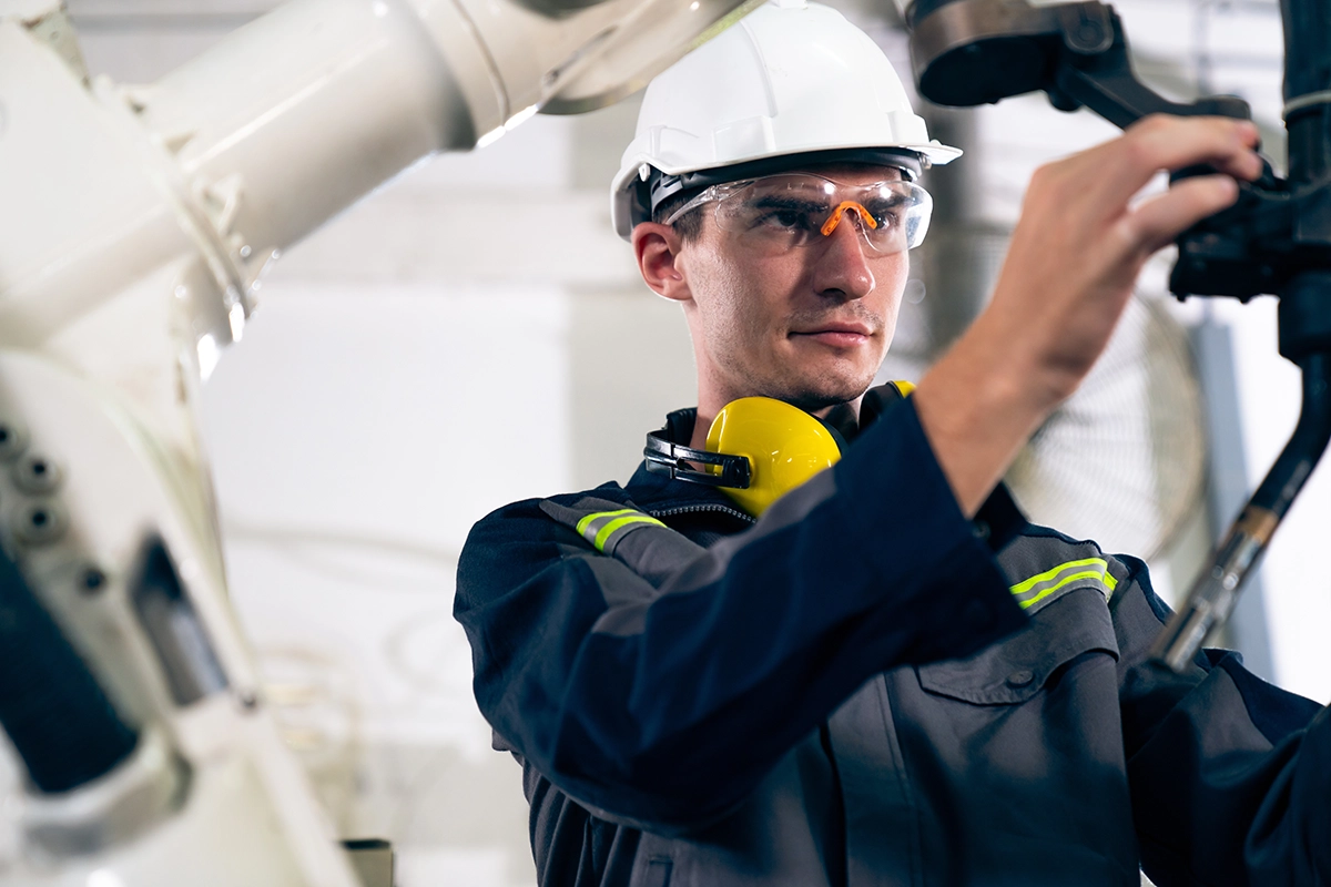 Medewerker in productieomgeving werkt aan industriële machine