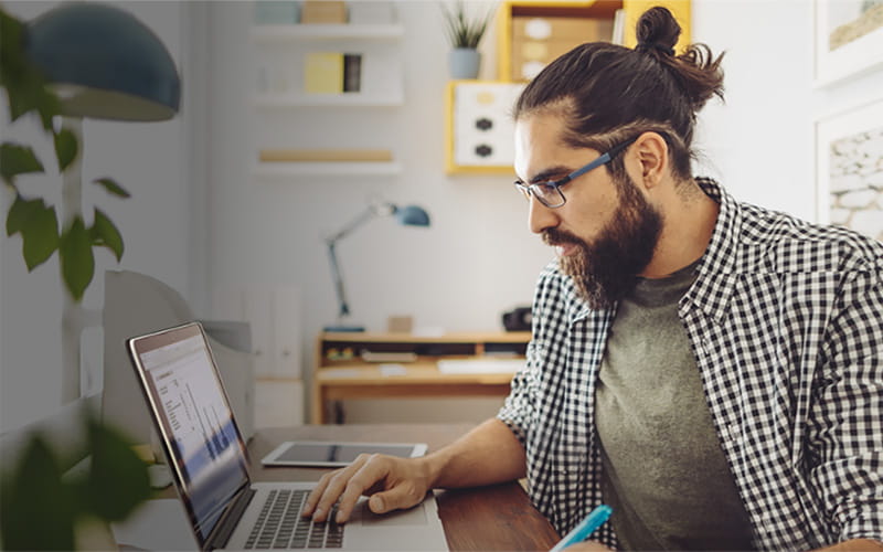 Man kijkt naar zijn laptop